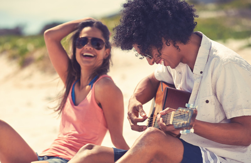 Couple sitting on beach at Town and Country Resort & Convention Center.