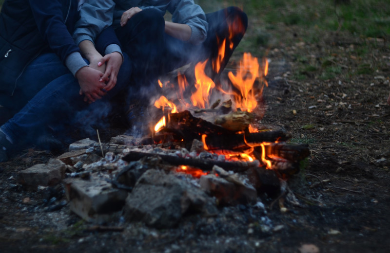 Couple by fire pit at White Glove Luxury Cabins.