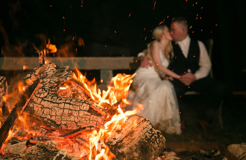 Couple by bonfire at Arrow Park Lake and Lodge.