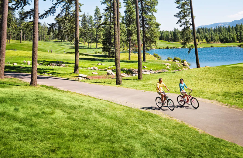 Couple biking on golf course at Suncadia Resort.