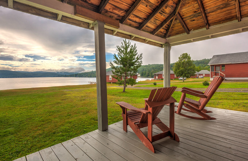 Meticulously clean country-style decorative rustic cabin porch at Jackson's Lodge and Log Cabin Village on international Lake Wallace, Canaan, Vermont.