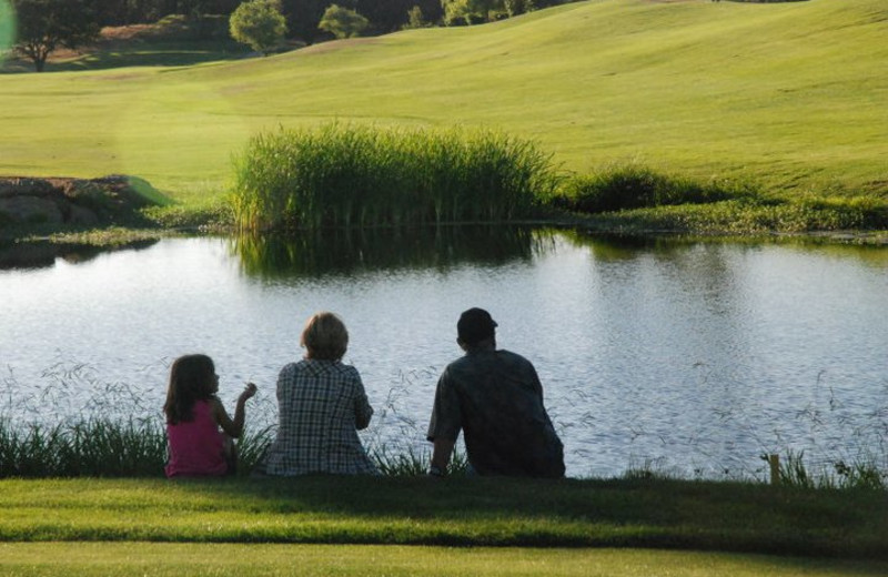 Family sitting by pond at Greenhorn Creek Resort.