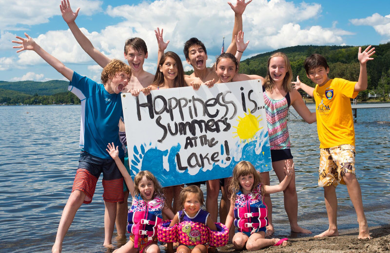 Kids on the sandy beach on international Lake Wallace at Jackson's Lodge and Log Cabin Village, Canaan, Vermont.