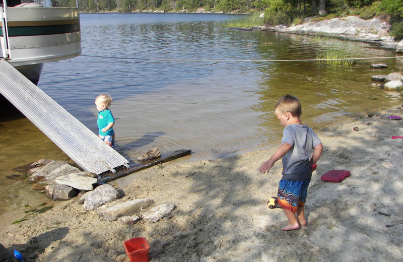 Family by the lake at Rainy Lake Houseboats.