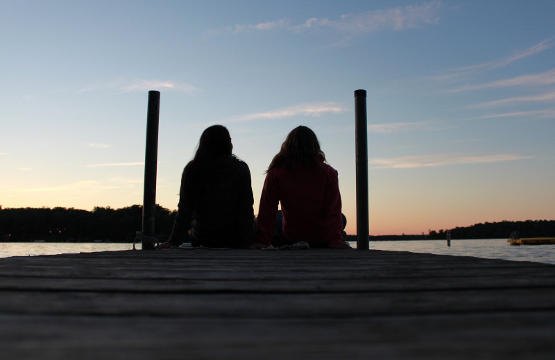 Couple sitting on dock at Woodland Beach Resort.