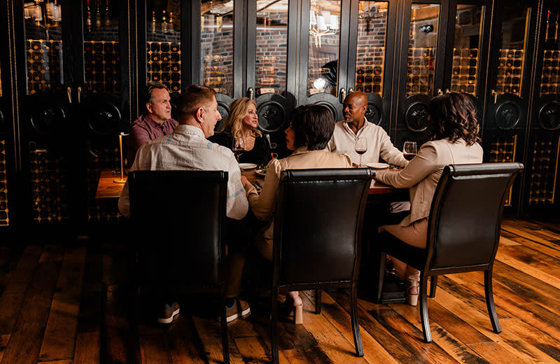 Adult friends and family member sitting in a wine-tasting room.