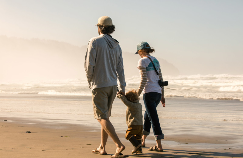 Family on beach at Beachhouse Vacation Rentals.