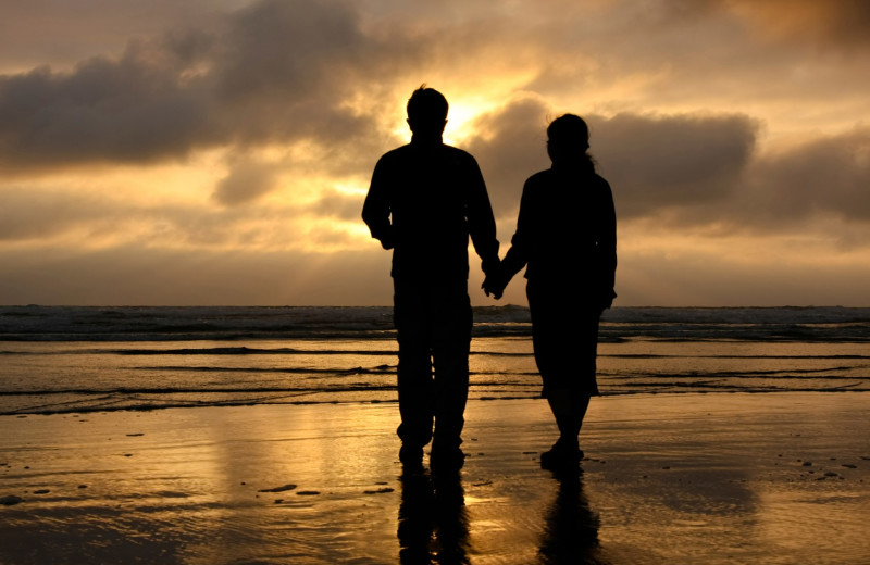 Couple holding hands on beach at Old Town Inn.