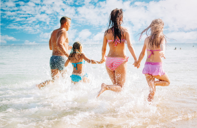 Family running into waves at Sea Star Realty.