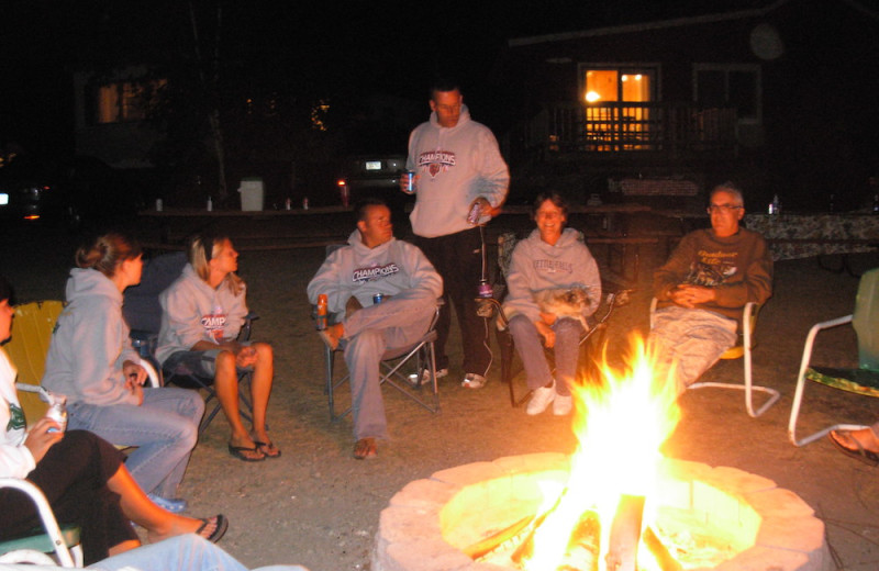 Family by the fire pit at Herseth's Tomahawk Resort.