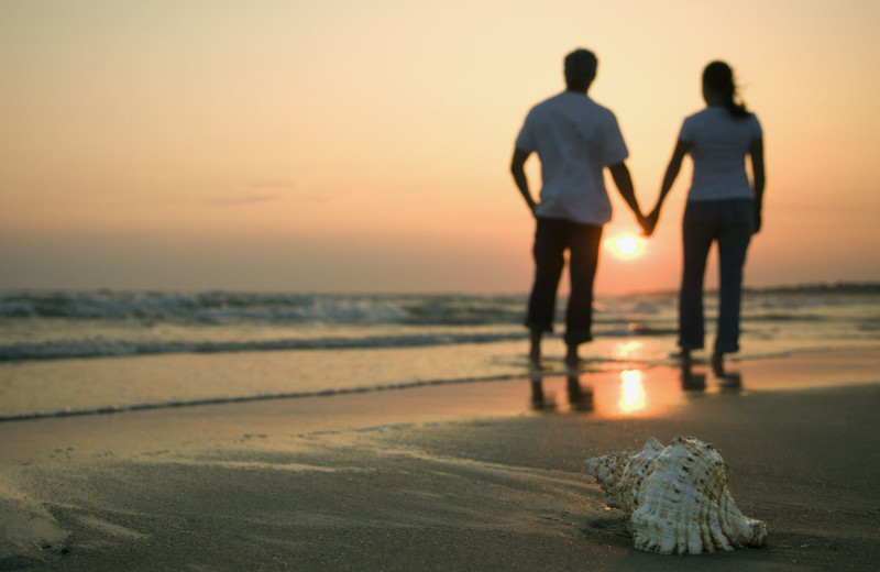 Couple holding hands on beach near Old Monterey Inn.