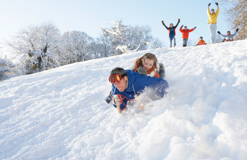 Family playing in snow at Red Cedar Lodge.