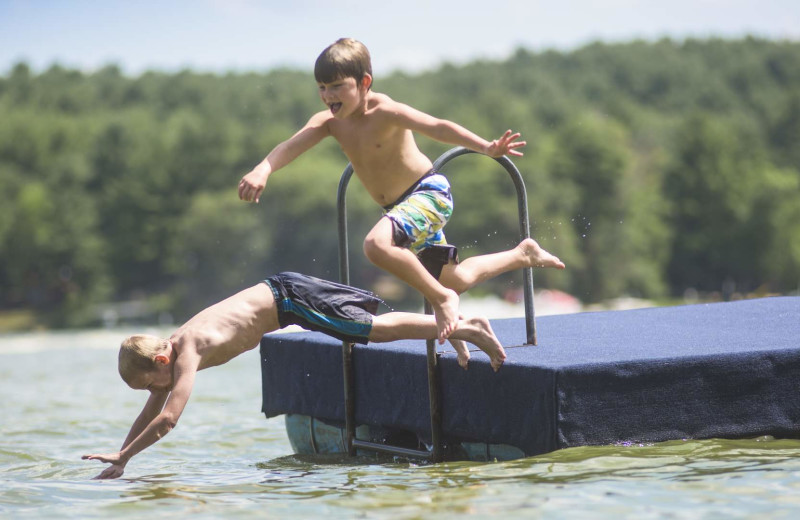 Kids jumping in lake at Delton Oaks Resort.