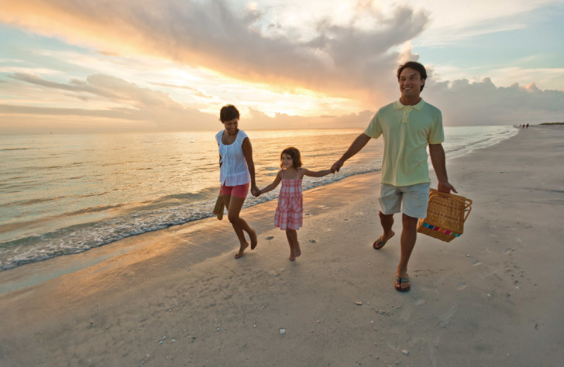 Family on beach at Teeming Vacation Rentals.