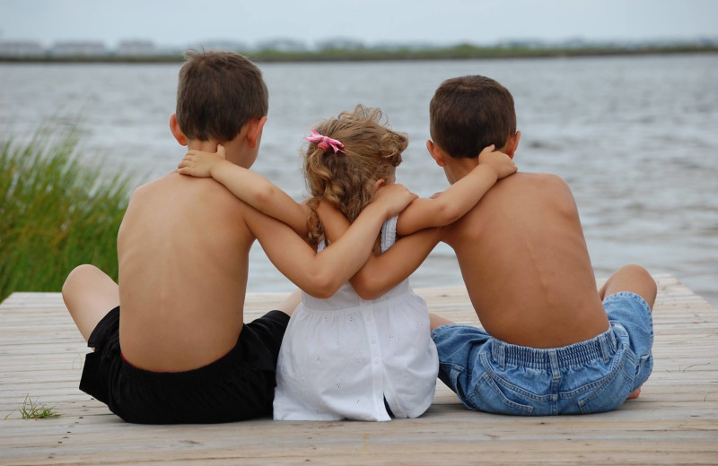 Family on beach at Pirate's Cove Realty.