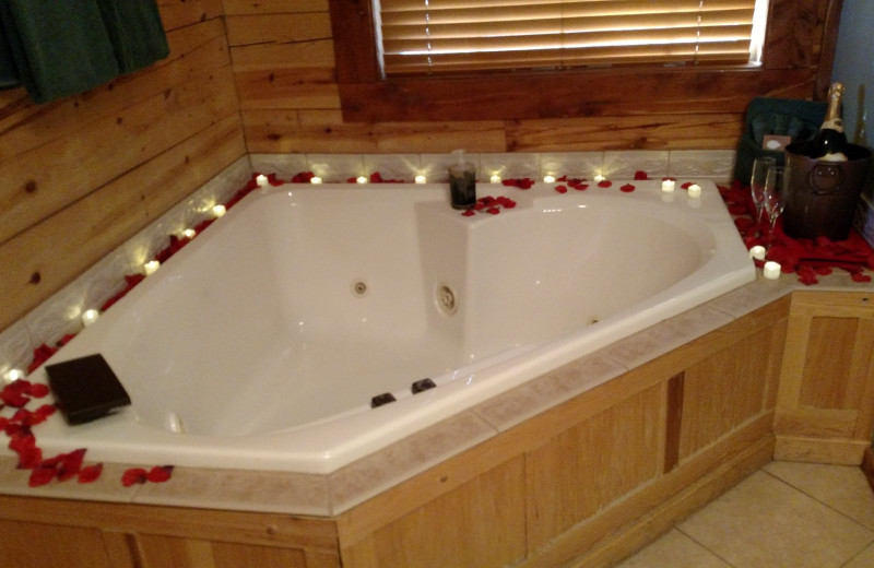 Hot tub with rose peddles at Lake Forest Luxury Log Cabins.