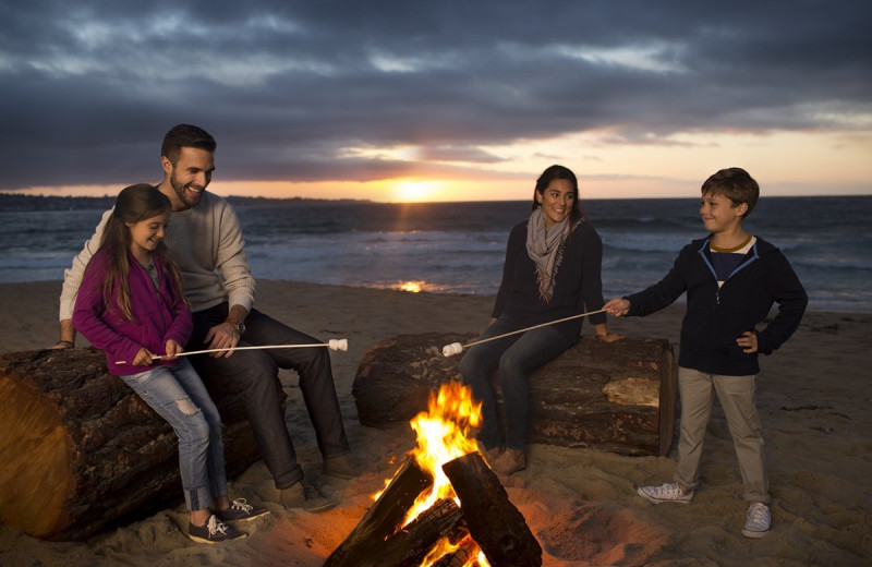 Family roasting marshmallows on beach at Monterey Tides.