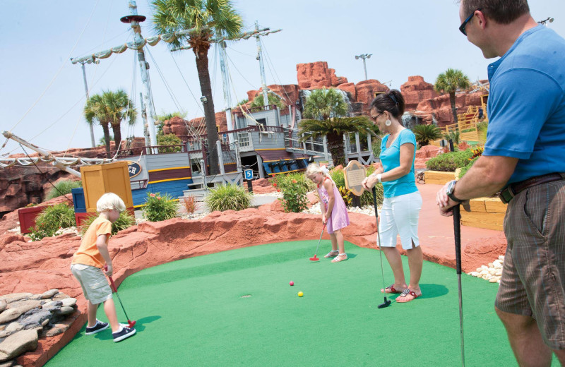 Family playing mini golf at The Strand Resort Myrtle Beach.