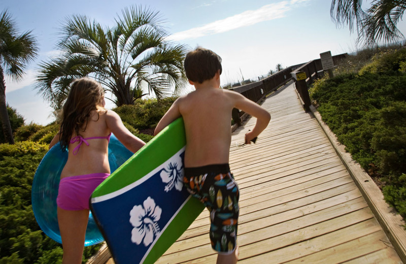 Kids running on boardwalk to beach at Beach Colony.