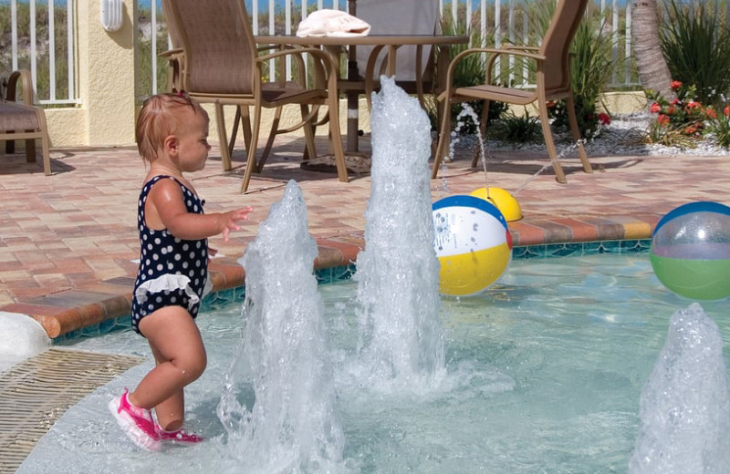 Kid splashing in pool at Sunset Vistas Beachfront Suites. 