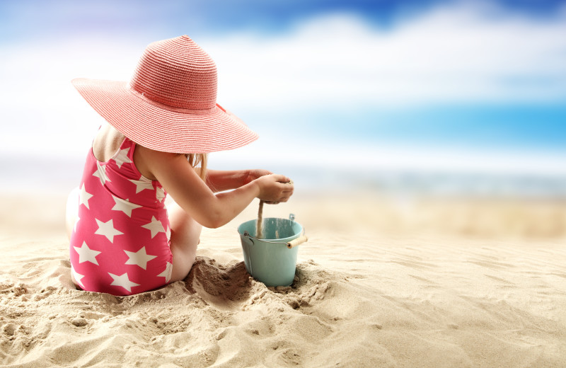 Baby with beach toys at Sea Star Realty.