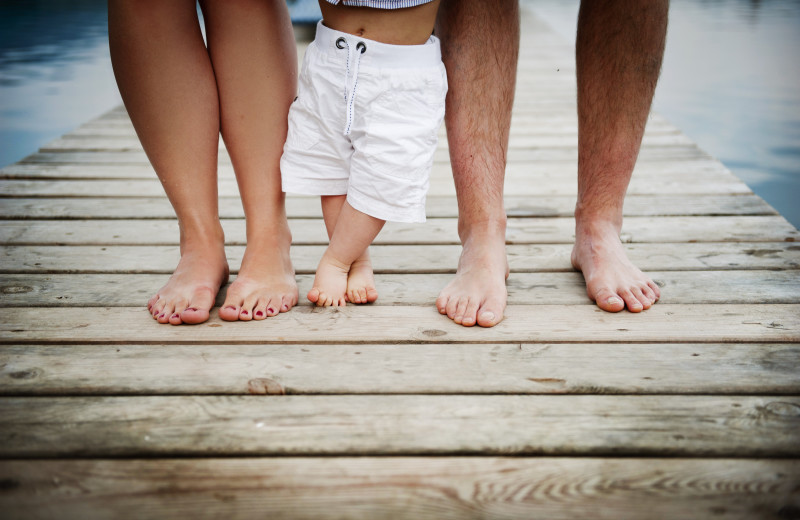 Family feet on dock at Sea Star Realty.