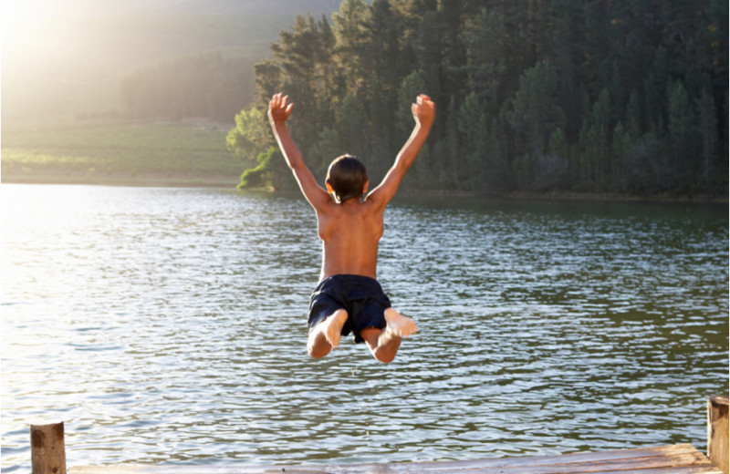 Jumping in the lake at The Woods At Bear Creek Glamping Resort.