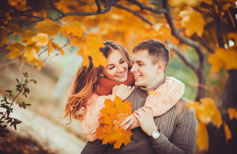 Couple hugging in fall leaves at Adobe Resort.