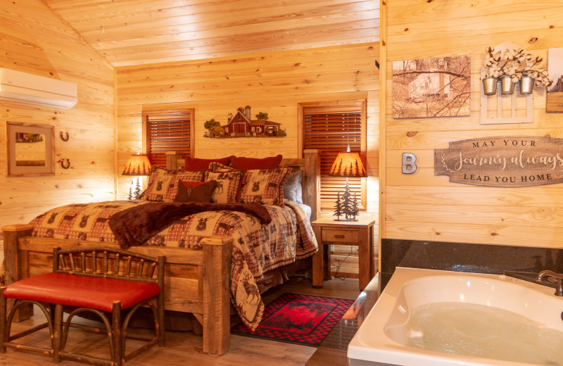 Cabin bed and hot tub at Harpole's Heartland Lodge.