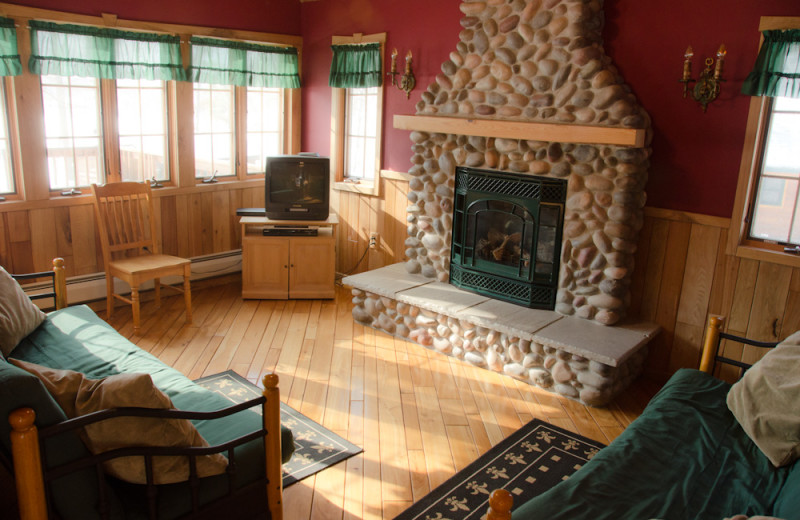 Cabin living room with fireplace at Tri Lake Timbers Resort.