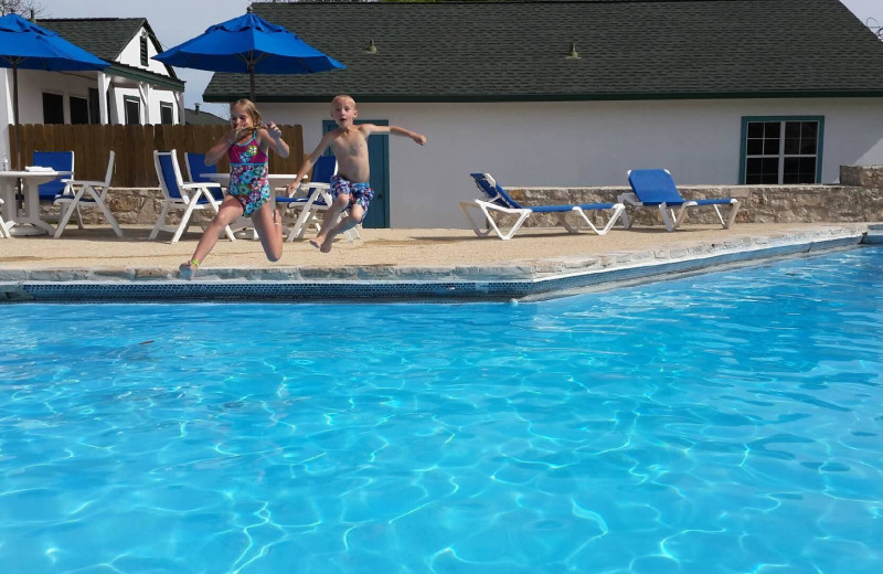 Kids jumping in pool at Peach Tree Inn & Suites.