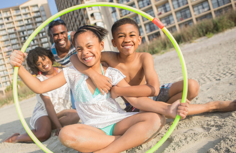 Family on beach at Beach Cove Resort.