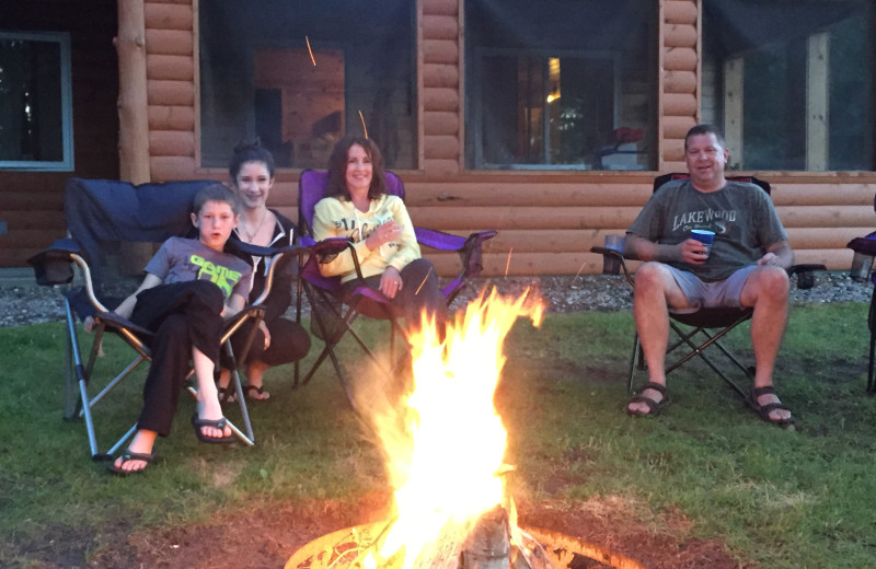 Family sitting around bonfire at Lakewood Lodge.