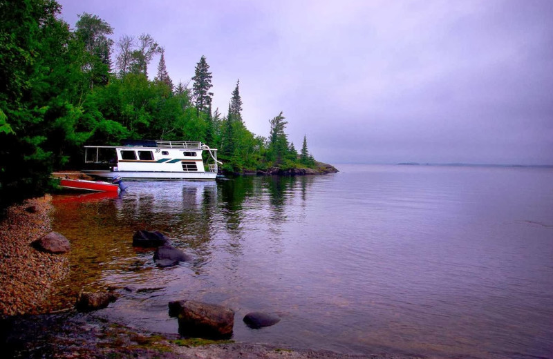 Houseboat docked on a sandy beach at Rainy Lake Houseboats.