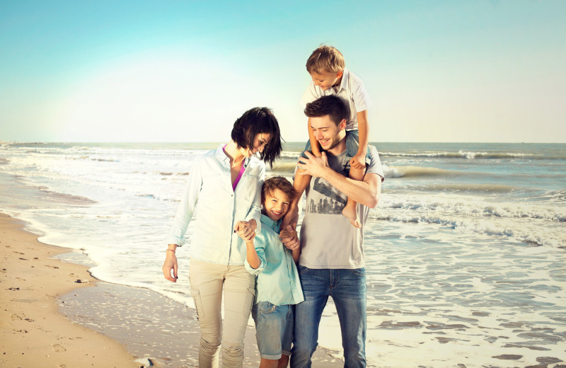 Family on beach at Beach-N-Bay Getaways.