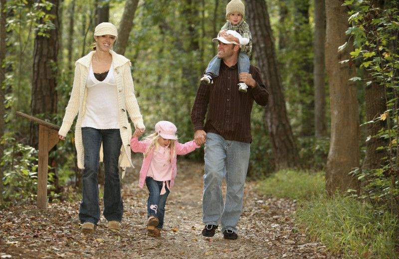 Family hiking in the woods at Whispering Woods Resort.