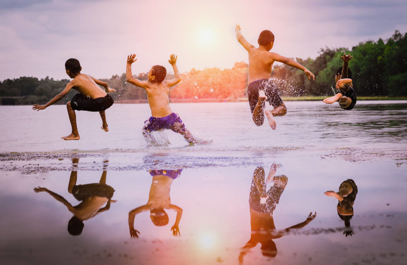 Kids jumping in lake at Finger Lakes Premiere Properties.