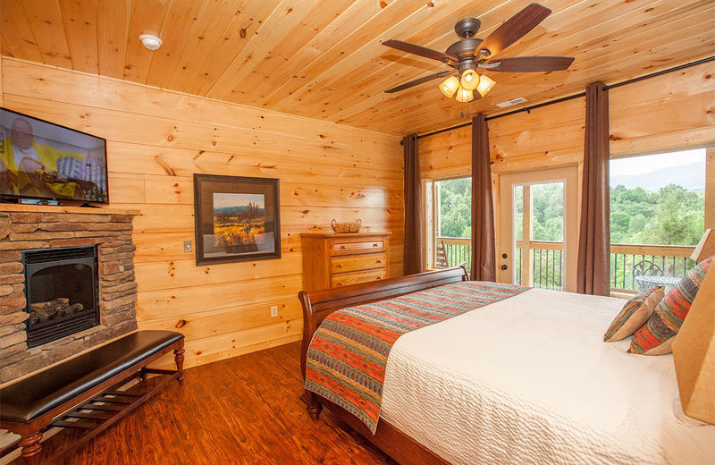 Cabin bedroom with fireplace at The Cabin Rental Store.