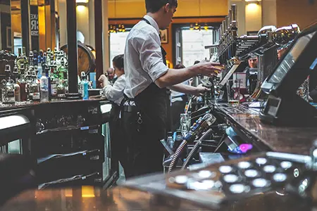 Barman hard at work in bust restaurant.