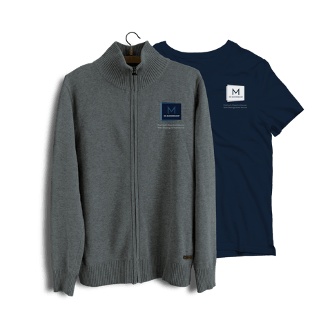 Mr. ShowerDoor’s updated logo on a zippered grey sweater and a blue t-shirt.