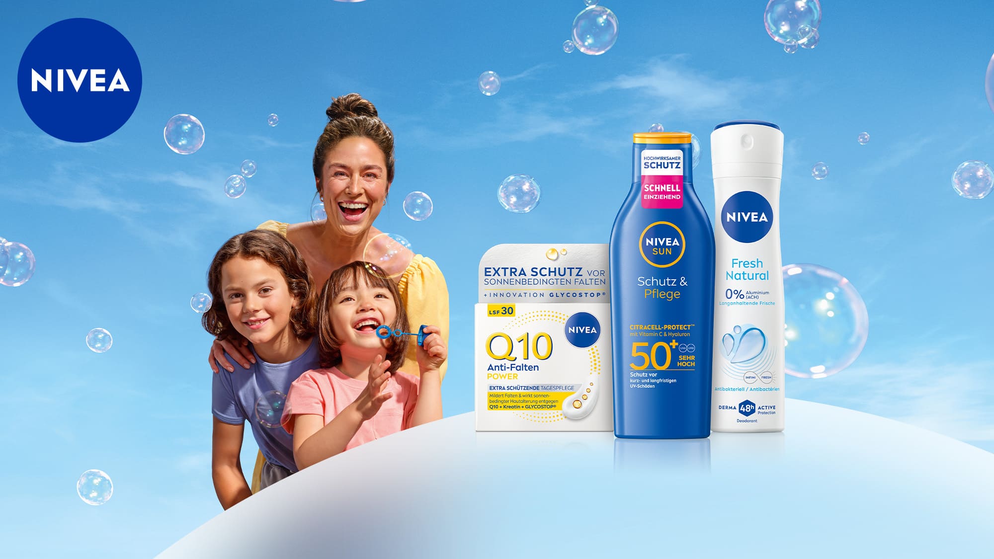 Werbebild der Marke Nivea vor blauem Himmel mit Seifenblasen. Oben links das Nivea-Logo. Links im Bild eine lachende Frau mit zwei fröhlichen Kindern. Rechts werden drei Produkte präsentiert: Nivea Q10 Anti-Falten Power Creme, Nivea Sun „Schutz & Pflege" Sonnenlotion, Nivea „Fresh Natural" Deospray. Verlinkung zum Coupon