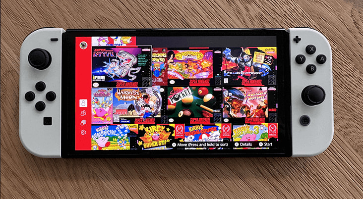 A Nitendo OLED Switch on a wooden surface displaying a selction of games from Nintendo Switch Online.