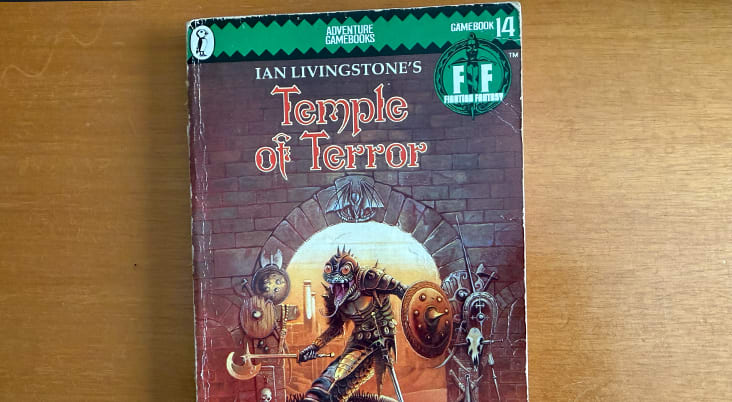 A collection of Fighting Fantasy books fanned out showing their illustrated covers.