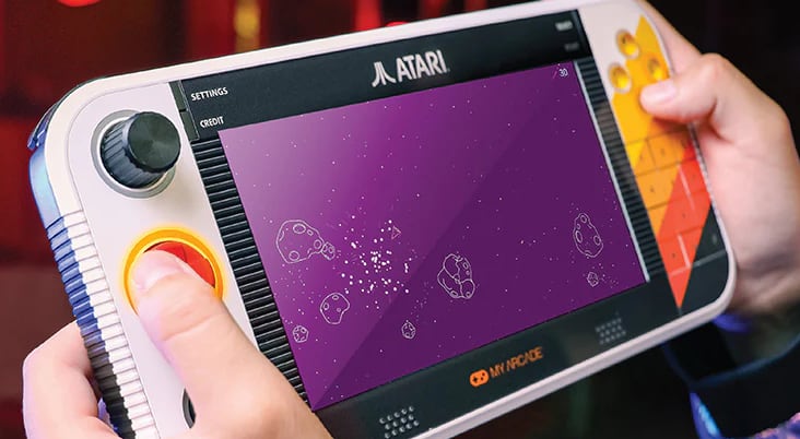 Close-up of someone playing the Atari Game Station Go handheld.