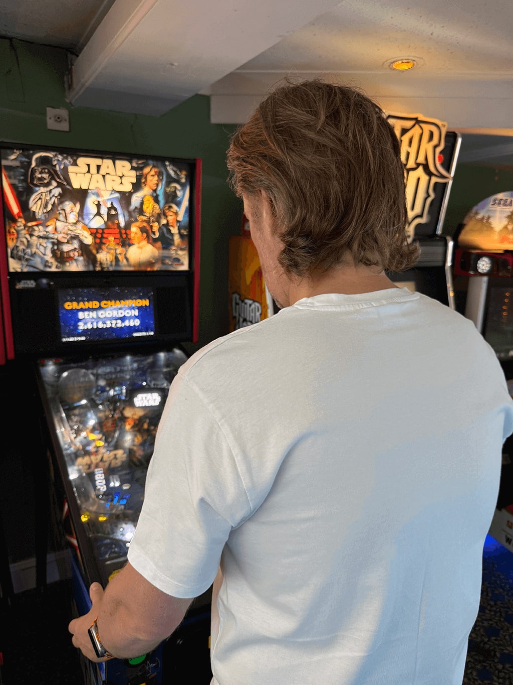 Lee Murray playing a starwars pinball machine.