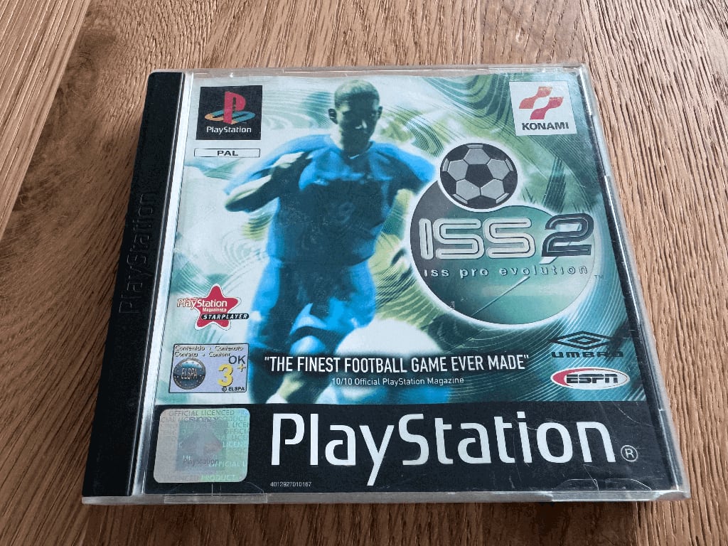 Pro Evo A copy of the Playstation 1 Pro Evolution Soccer 2 game in a case in a wooden table top.