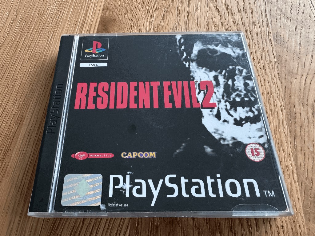 Resident Evil A copy of the Playstation 1 Resident Evil 2 game in a case in a wooden table top.