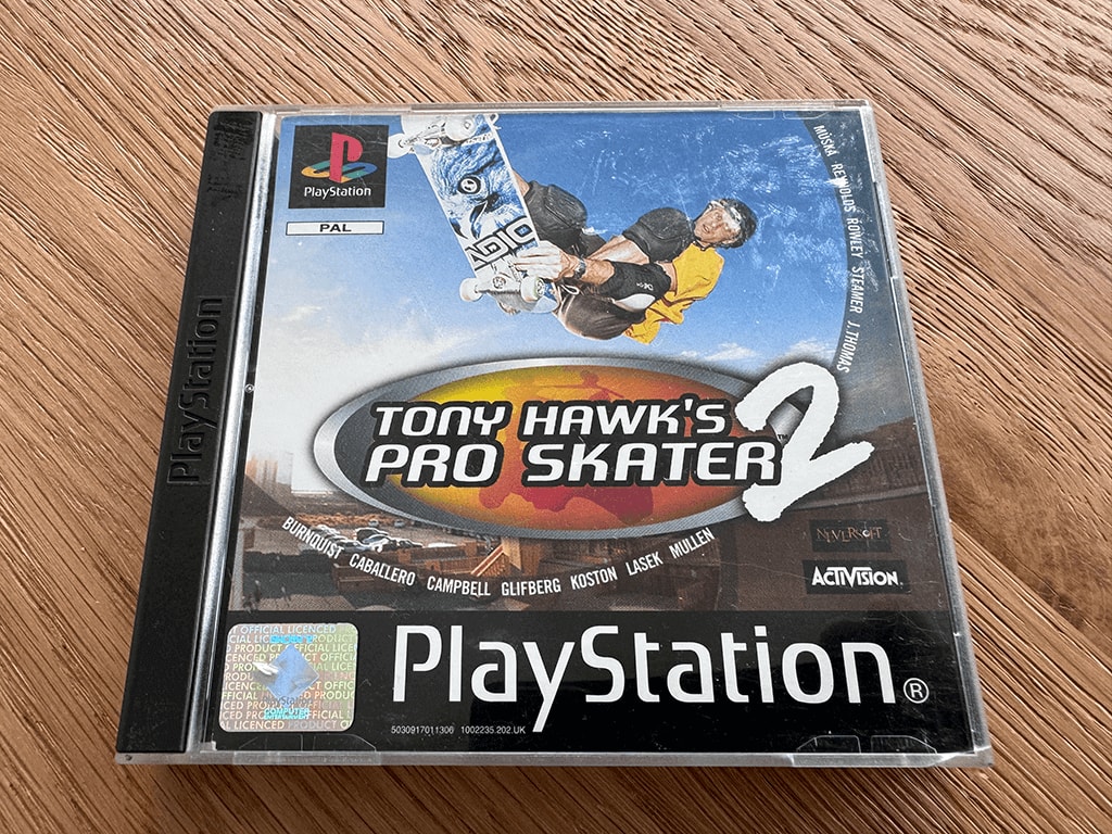 Tony Hawks A copy of the Playstation 1 Tony Hawks Pro Skater 2 game in a case in a wooden table top.