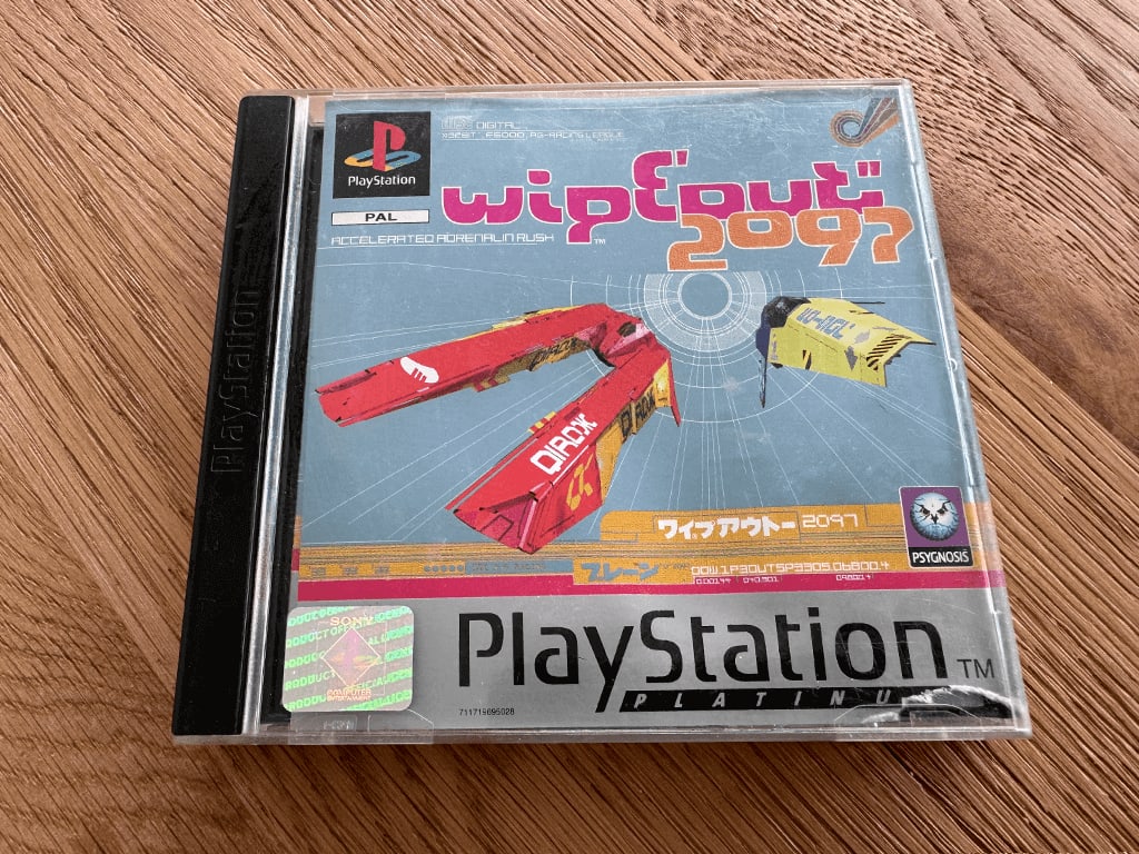 Wipeout A copy of the Playstation 1 Wipeout 2097 game in a case in a wooden table top.