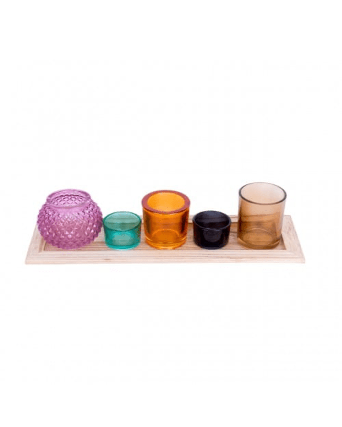 a group of colorful glass candlesticks on a wooden tray